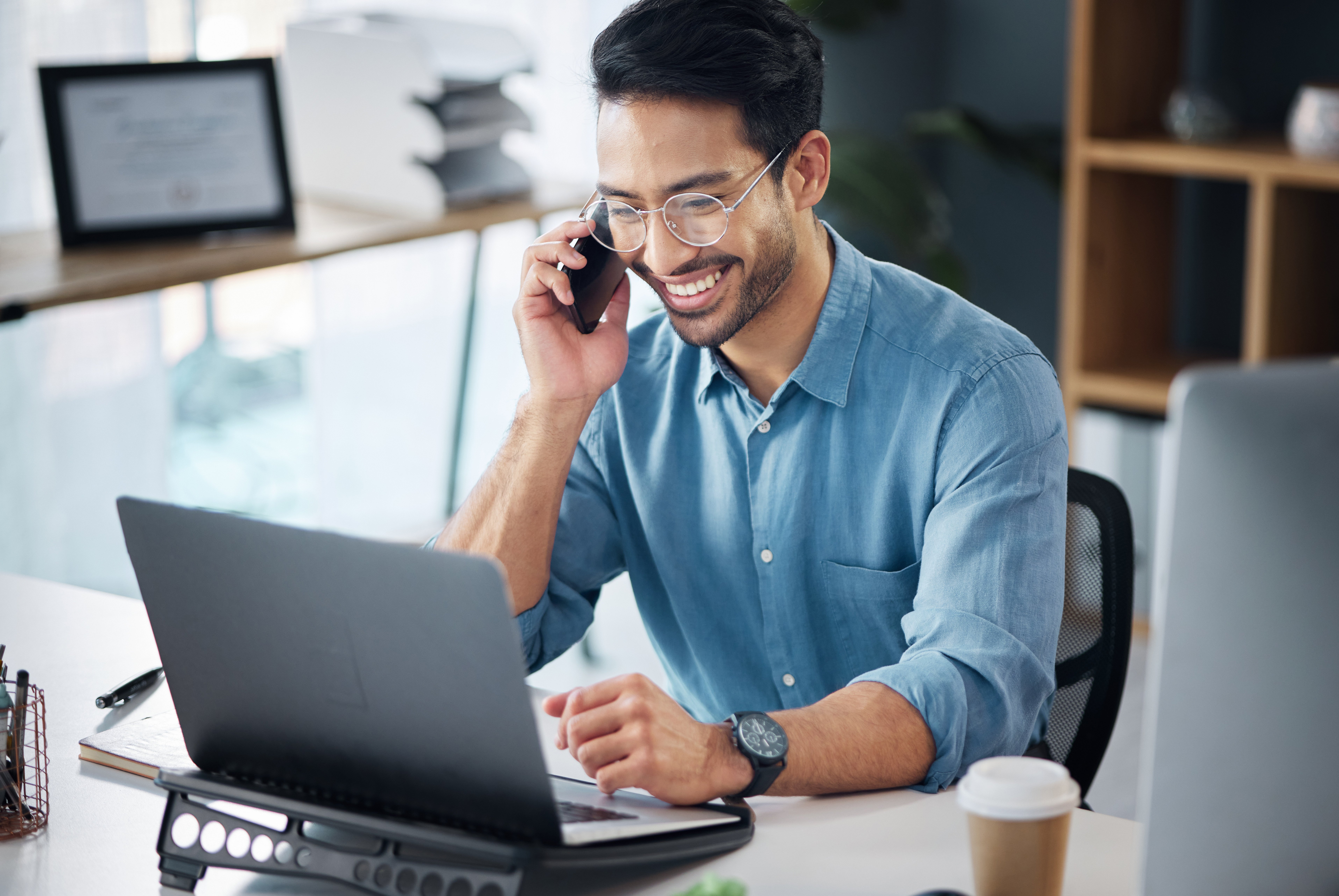 Man on Phone and Laptop in Office